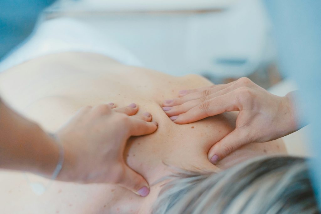 „Therapeutische Rückenmassage: Hände massieren gezielt die Muskulatur, zur Linderung von Verspannungen und Förderung der Entspannung.“